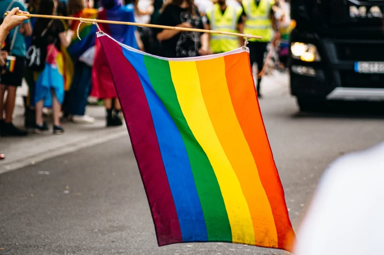 Regenbogenflagge auf Straße schwenkend